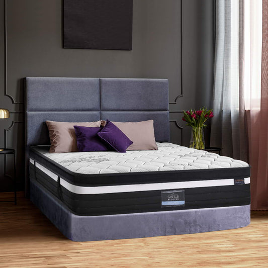 A king-sized Giselle Bedding mattress with a super firm structure displayed in a bedroom setting, featuring a grey knitted fabric on top and a label indicating the brand and model.