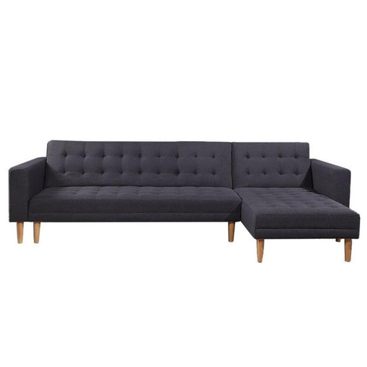 A dark grey linen upholstered corner sofa with tufted surface and wooden legs, featuring a chaise lounge.