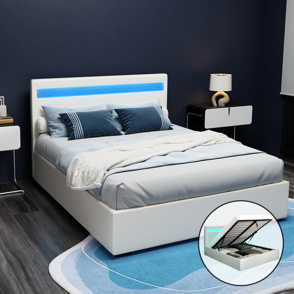 A white double-sized Artiss LED gas lift bed frame with a padded headboard and footboard, upholstered in PVC leather. The image shows the bed with the LED lights on the headboard and a storage compartment underneath highlighted.