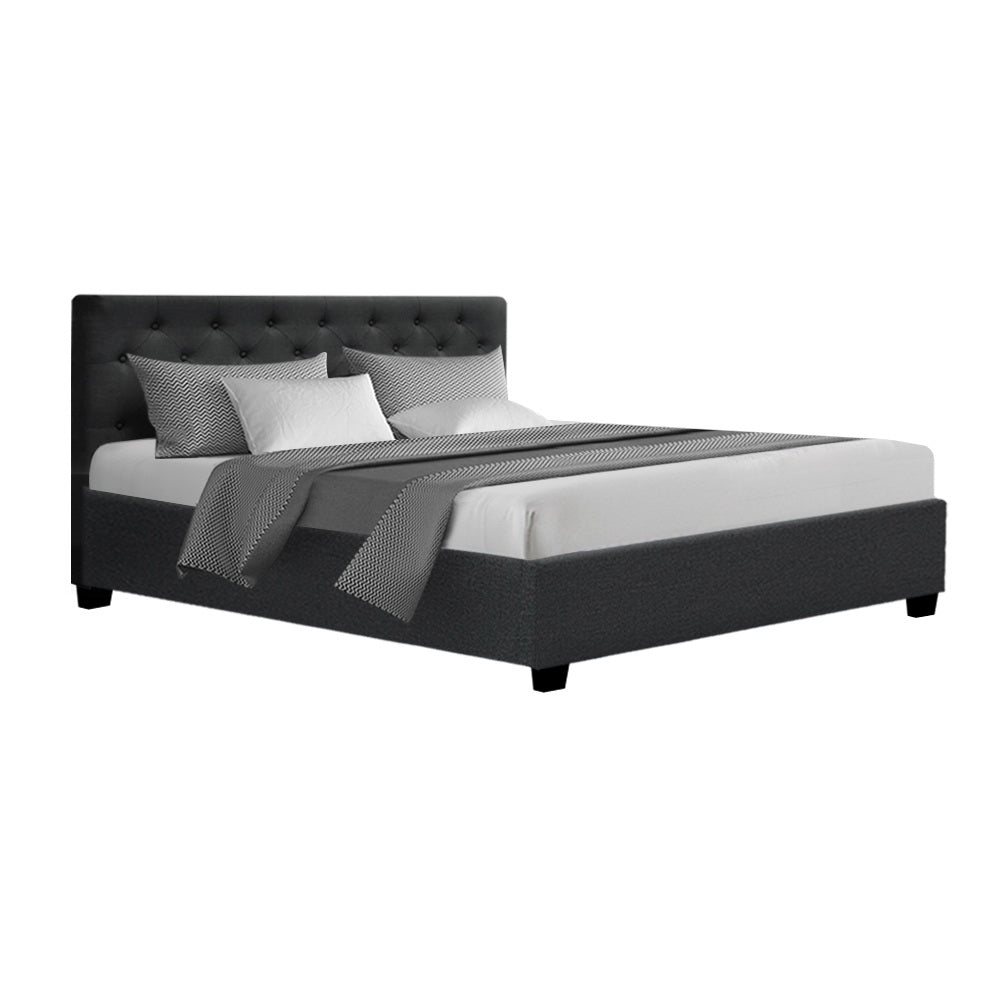 Black upholstered bed with white bedding on a white background
