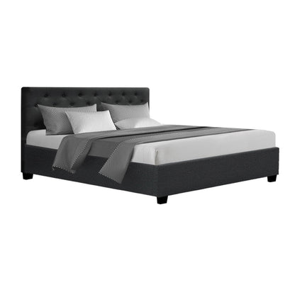 Black upholstered bed with white bedding on a white background