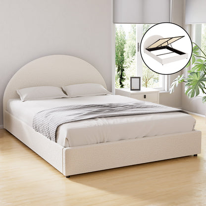 White upholstered bed with round headboard in a bright room with large windows.