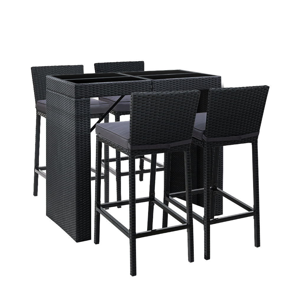A five-piece outdoor bar set with a rectangular dining table and four matching bar stools, all in black color with a wicker finish. The stools have grey cushions.