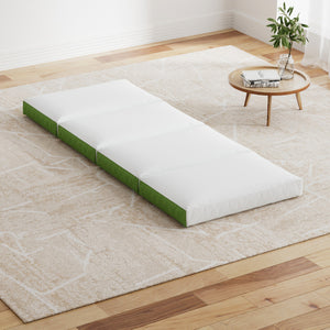 Foldable foam mattress laid out on the floor in a living room setting, showcasing its white and green dual-colored cover.
