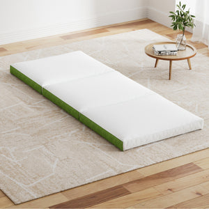 A foldable foam mattress laid out on the floor in a room with a white and green color scheme.
