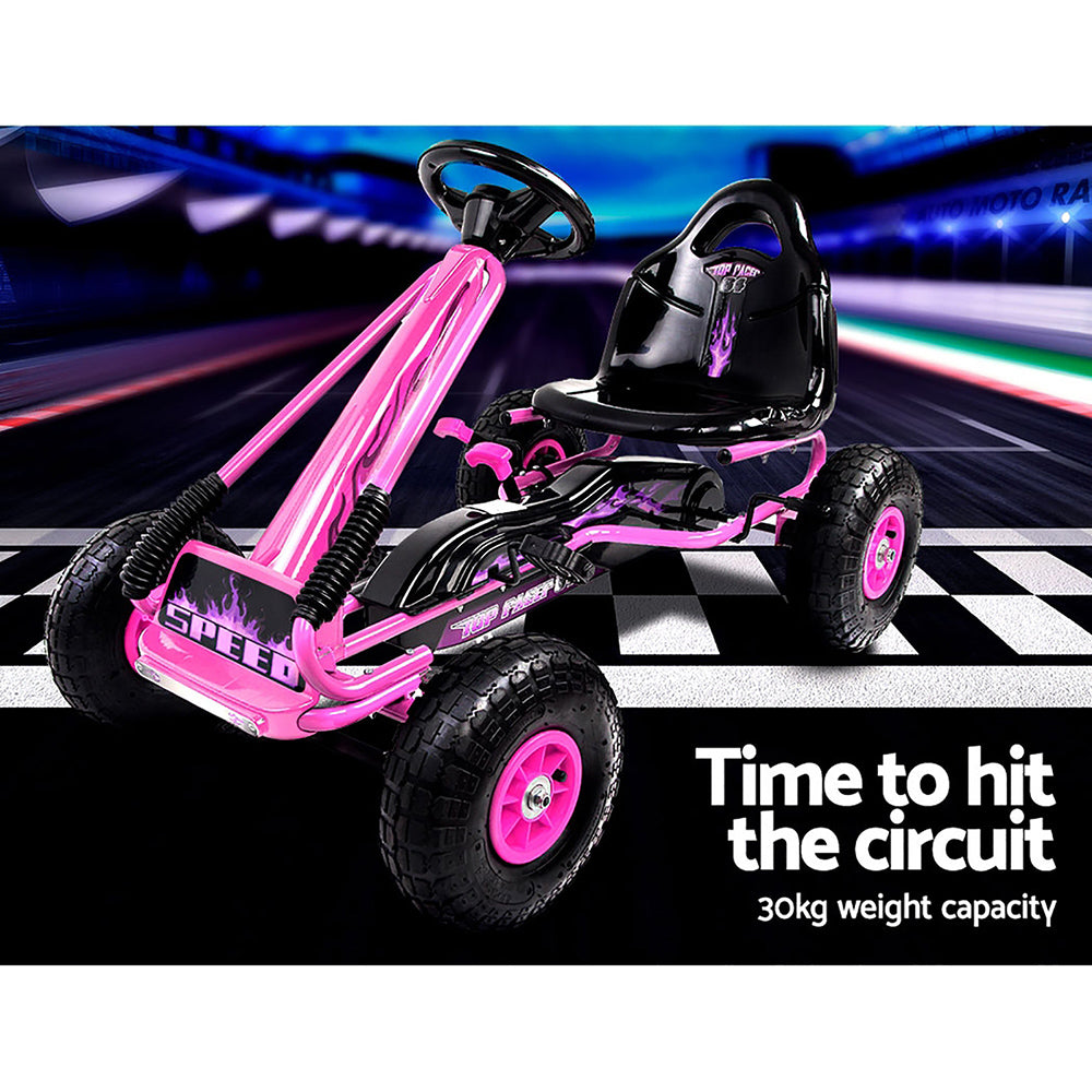 Pink and black pedal go-kart on a racetrack with text about weight capacity.