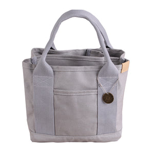 Canvas Lunch Tote Bag - Stylish Handbag with Multiple Compartments for Women

Effortlessly keep all your must-haves in order with the Canvas Lunch Tote Bag for Women. This stylish yet functional handbag is expertly crafted from high-quality canvas and equipped with a durable handle for convenient transport. Its sleek design boasts multiple compartments, including a roomy main section for lunch boxes, books, or an iPad, and side pockets for water bottles, pens, or small essentials. Perfect for work, school, 