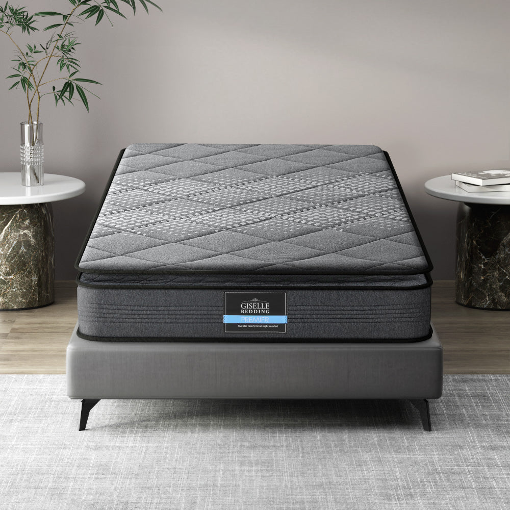 A king single sized Giselle Bedding mattress pillow top on a bed frame, displayed in a room setting with decorative items around.