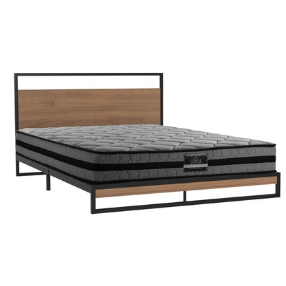 Gray mattress on a metal and wood bed frame with a white background