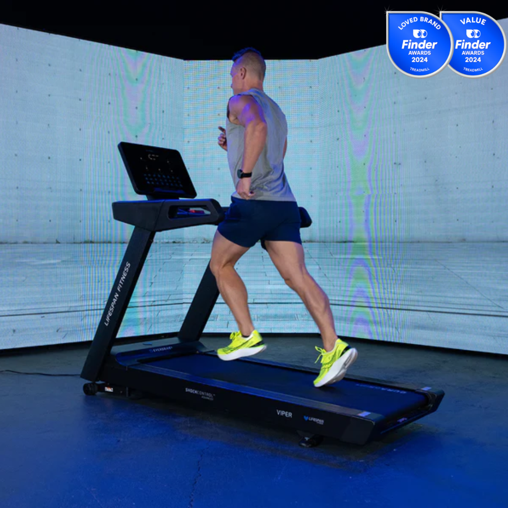 Person running on a treadmill with a digital display, set against a white wall.