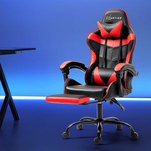 A red and black Artiss gaming office chair with a footrest, positioned in a workspace setting.