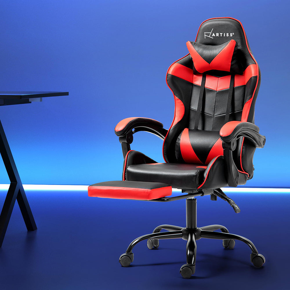 A red and black Artiss gaming office chair with a footrest, positioned in a workspace setting.