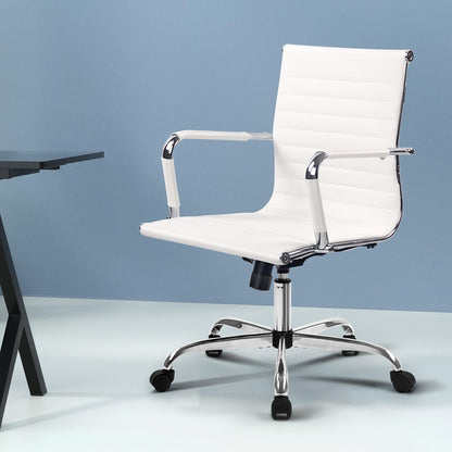A white, mid-back Artiss gaming office chair with a chrome base and five wheel castors, displayed in a modern interior setting.