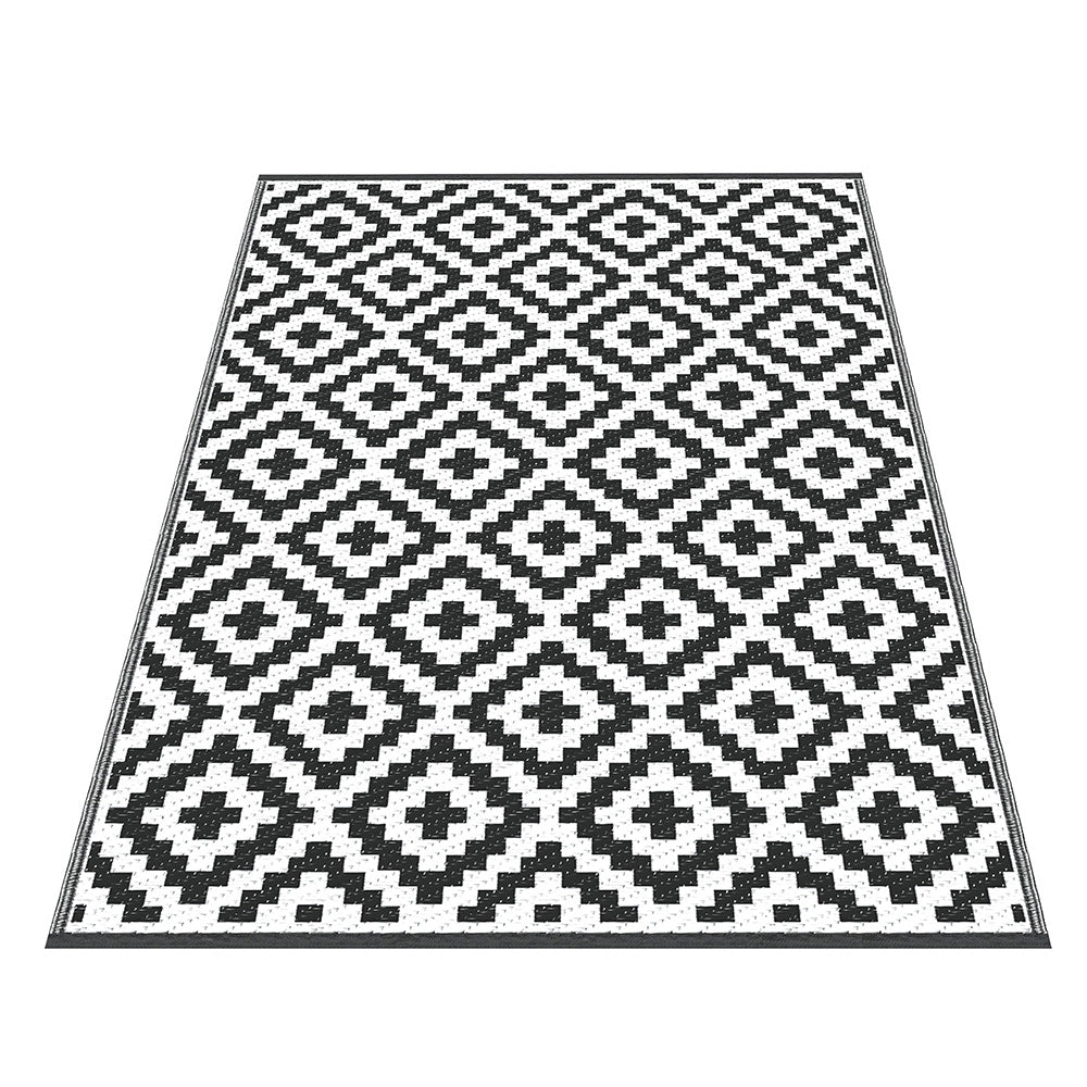 Black and white geometric patterned rug on a white background