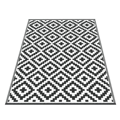 Black and white geometric patterned rug on a white background