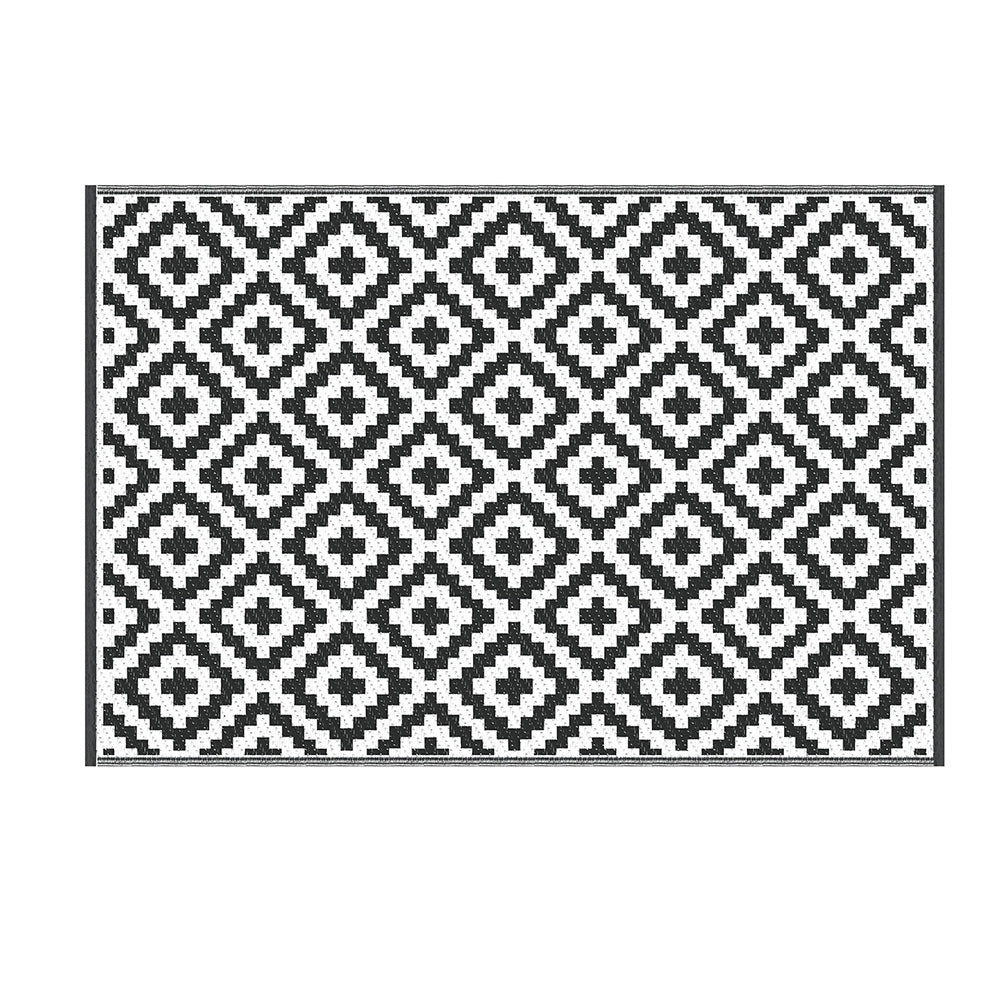 Black and white geometric patterned rug on a white background