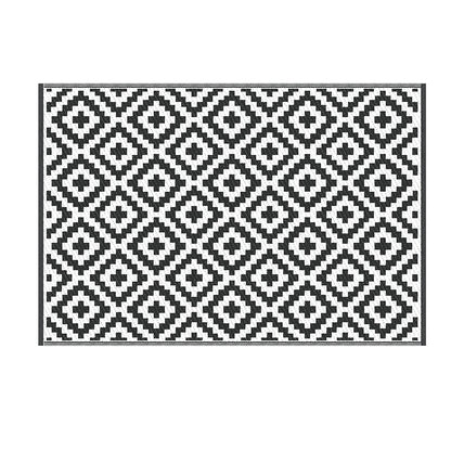 Black and white geometric patterned rug on a white background