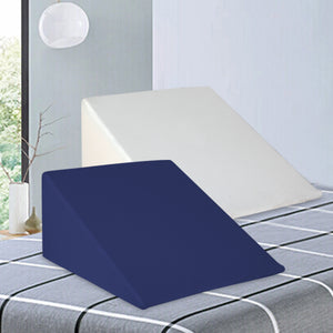 A blue and white striped wedge pillow on a bed with a white headboard, in a bedroom setting.