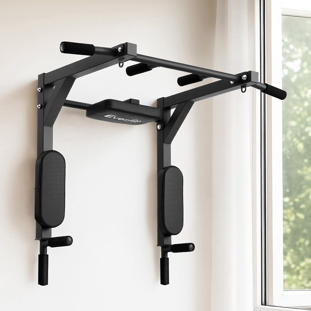 Black pull-up bar mounted on a white wall next to a window.