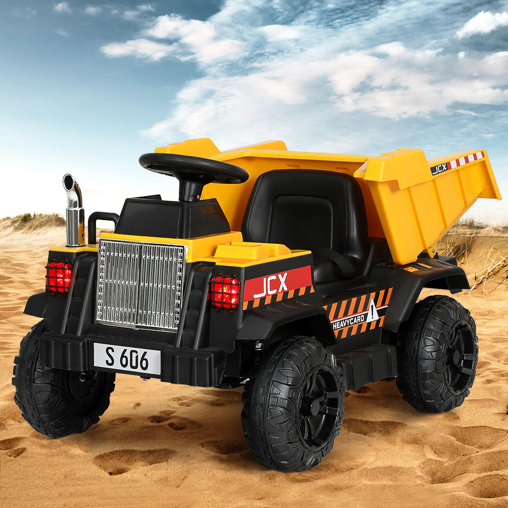 Toy dump truck with black and yellow colors on a sandy background