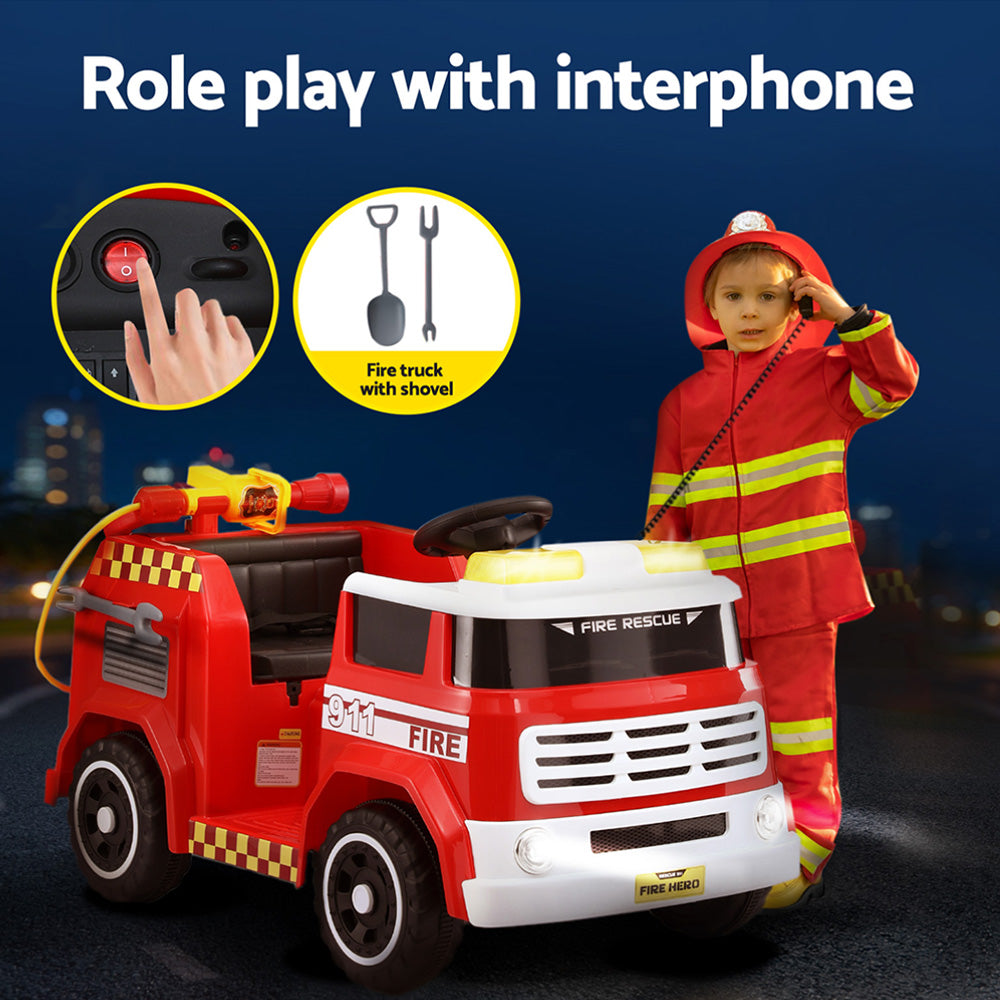 Child in fireman costume with toy fire truck and interphone on a dark background