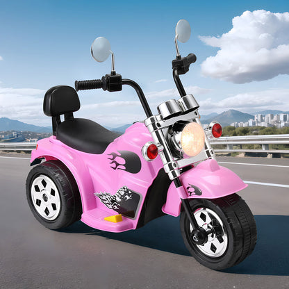 Pink toy motorcycle on a road with a scenic background