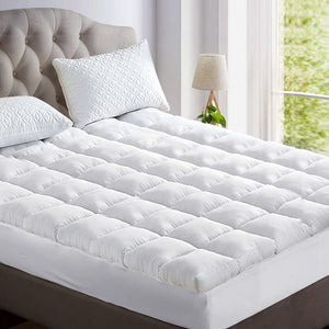 A white bamboo mattress topper on a king-sized bed, featuring a plush, padded surface with a pillowtop design.