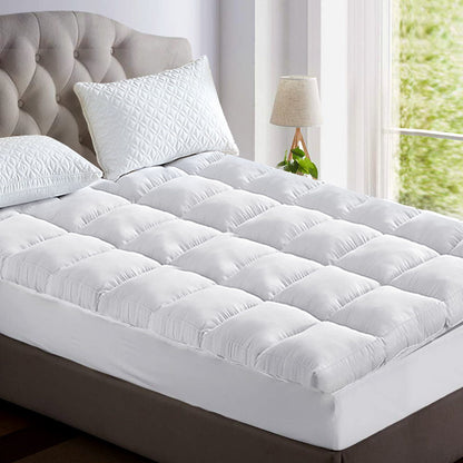 A white bamboo mattress topper on a single bed, with a pillow matching the topper.