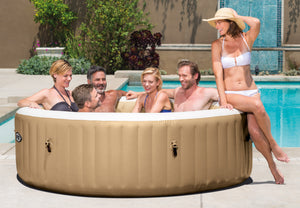 Group of people relaxing in an inflatable hot tub by a pool.