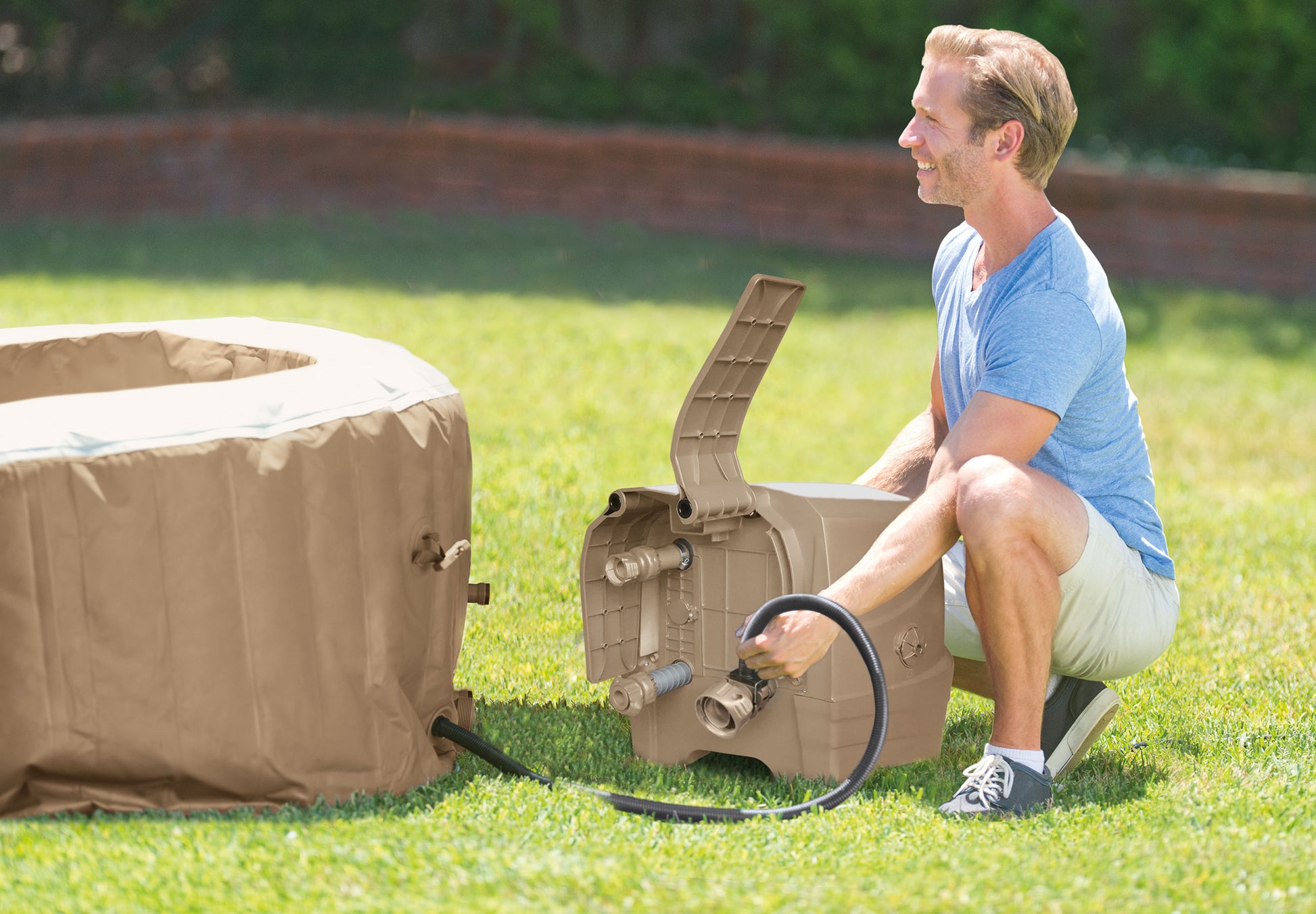 Person setting up a portable hot tub on grass