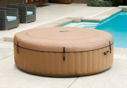 Inflatable hot tub on a patio with a pool in the background