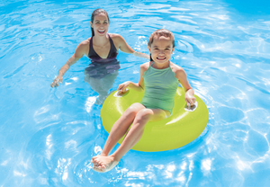 Two children playing in a pool with a green inflatable ring.