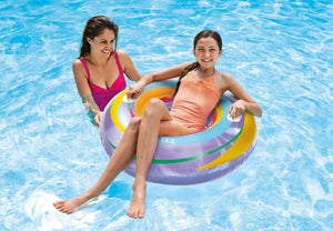 Two women in a pool with a colorful inflatable ring.