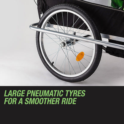 Close-up of a bicycle trailer wheel with large pneumatic tyres on a gray background.