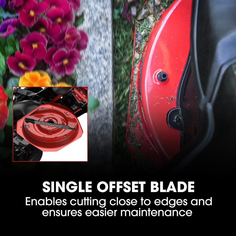 Red lawn mower with single offset blade feature, surrounded by flowers and water.