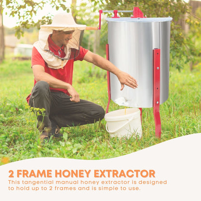 Person using a 2 frame honey extractor in a natural setting