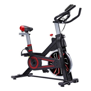 A red and black Powertrain RX-600 exercise spin bike with adjustable seat and handlebars, featuring an LCD display and a large flywheel.