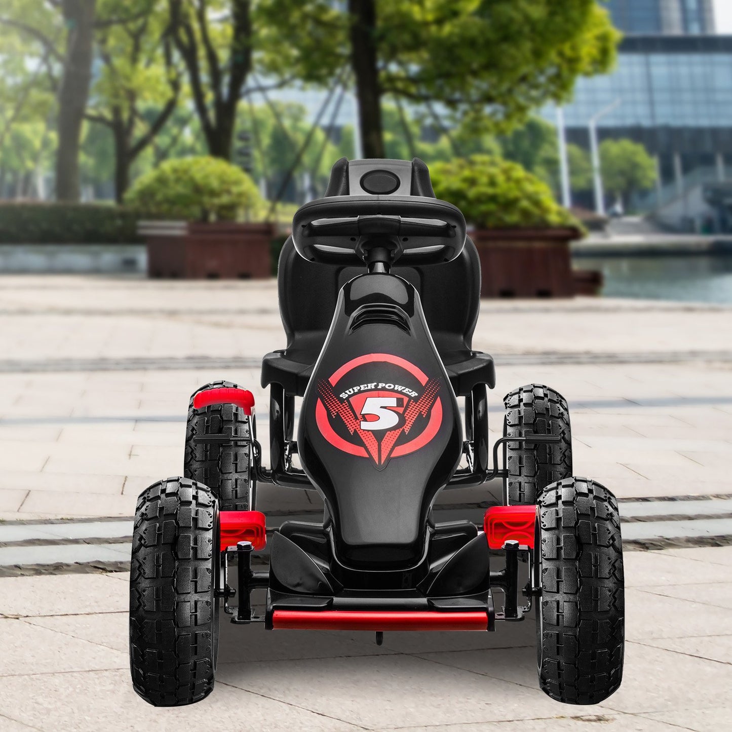 Black and red toy car with 'Super Power' logo on a paved area with trees and buildings in the background