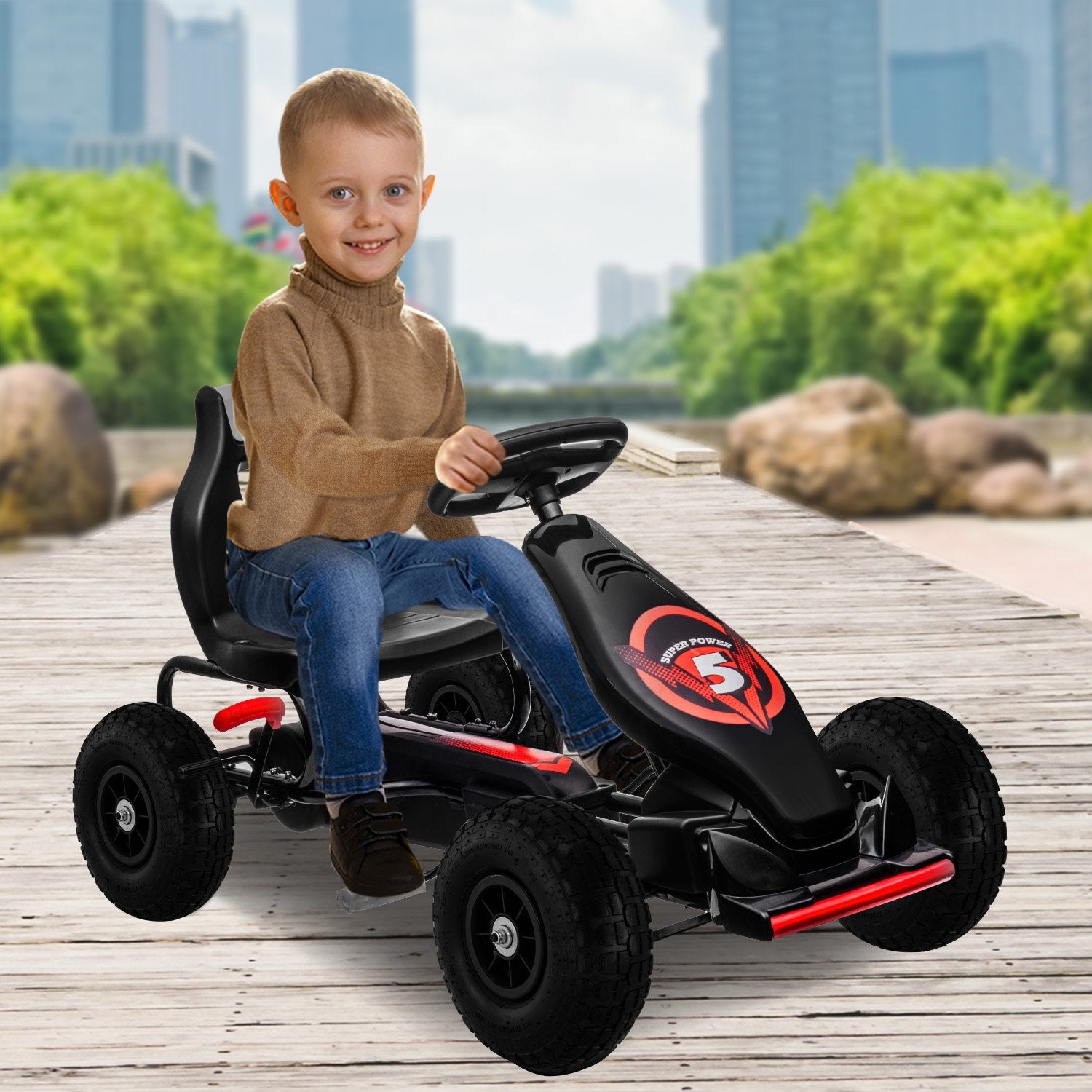 Child sitting on a black and red go-kart with a cityscape background