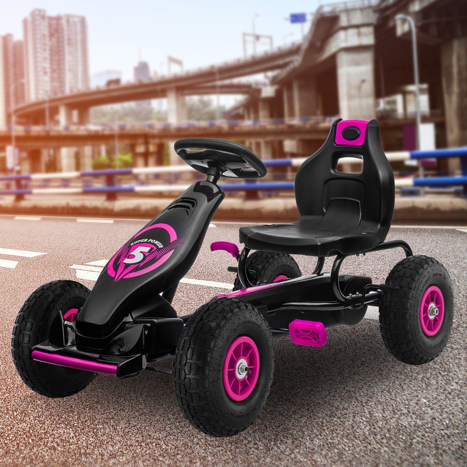 Black and pink children's go-kart on a road with a blurred urban background