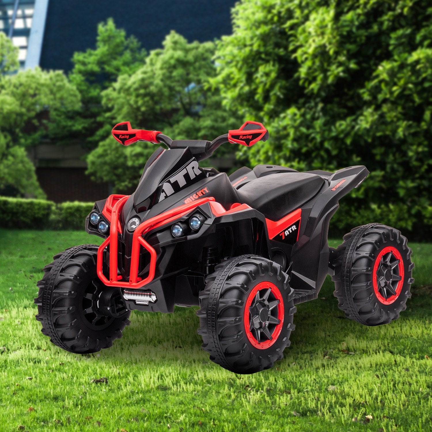 Black and red ATV toy on grass with green bushes in the background