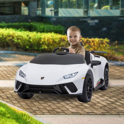Child sitting in a toy sports car on a paved area with greenery in the background