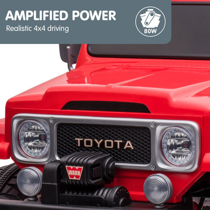 Red toy truck with Toyota logo and Warn winch, featuring 'Amplified Power' text and logo.