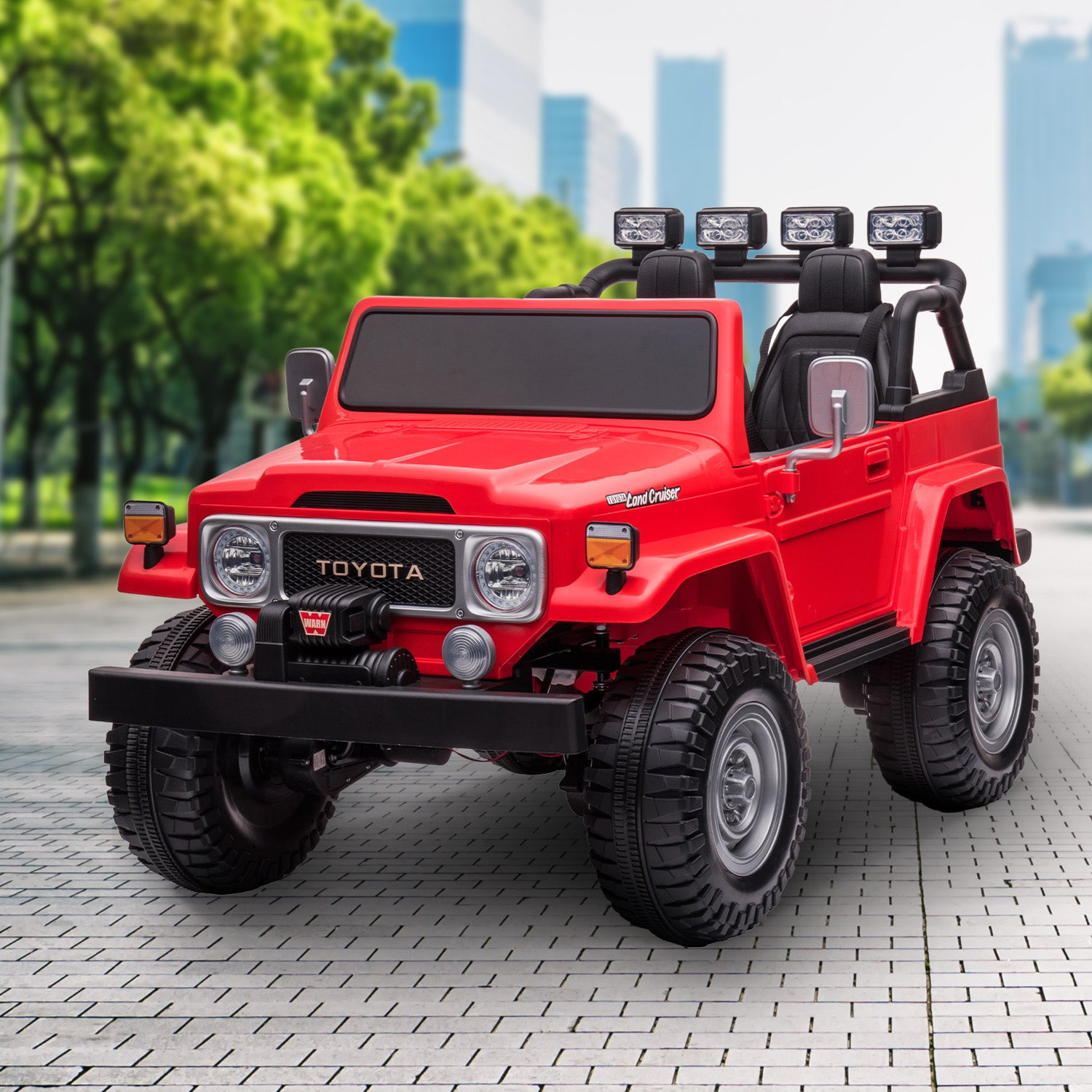 Red toy truck with Toyota branding on a paved surface with trees and buildings in the background