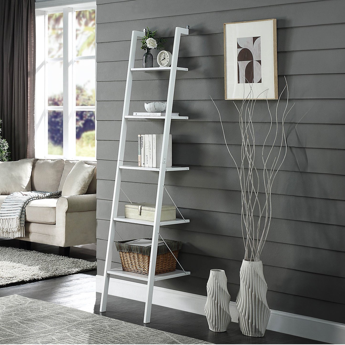 White ladder shelf against a gray wall with decorative items in a living room.