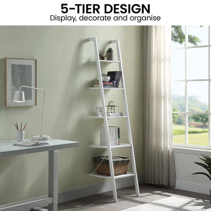 White ladder shelf with five tiers in a room with a desk and window.