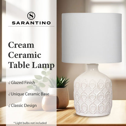 Cream ceramic table lamp with geometric design on a wooden surface, featuring Sarantino brand.