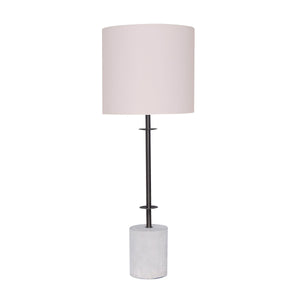 A table lamp with a concrete base and a white linen drum shade, with a sleek metal pole.