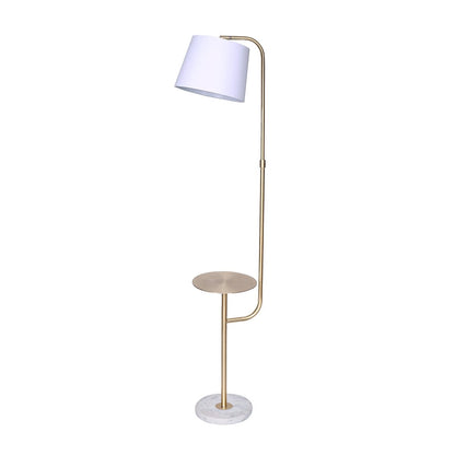 An adjustable floor lamp with a brushed brass finish, marble base, and a metal shelf that doubles as an end table. It has a white tapered lampshade.