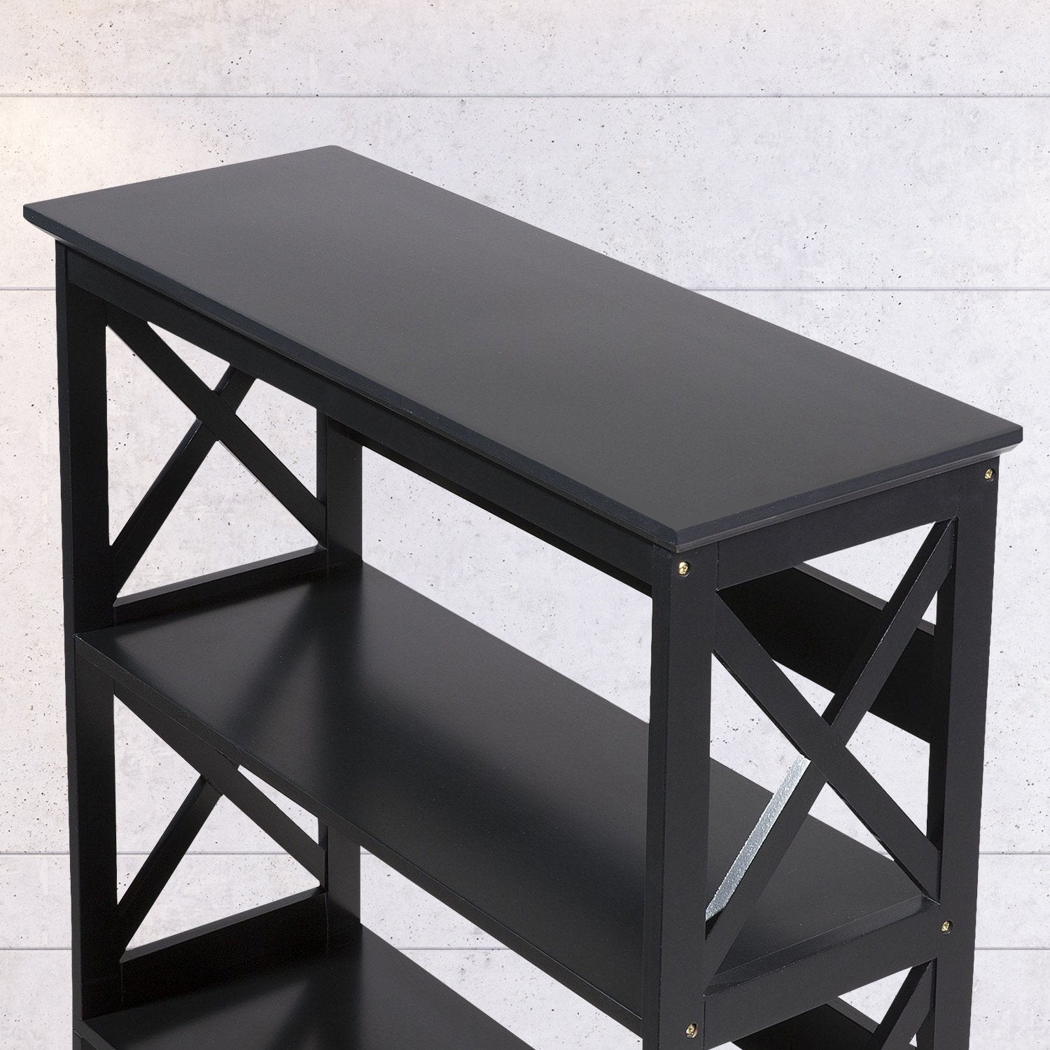 Black console table with cross-brace design on a light gray background